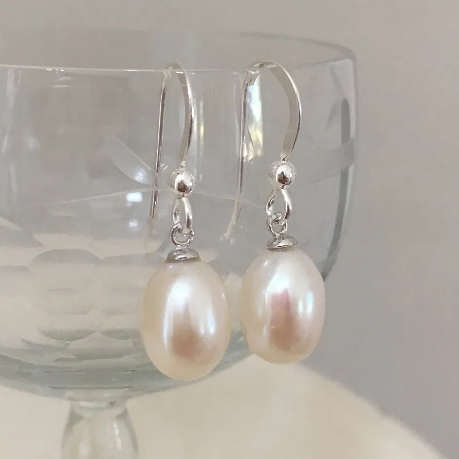 Pearl earrings with medium freshwater natural white oval pearl drops on silver hooks